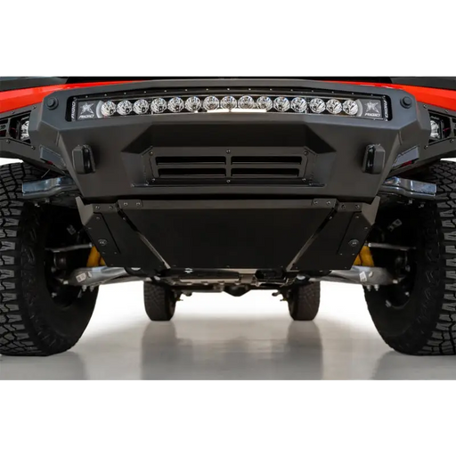 Red truck with light displaying the Ford Bronco Stealth Fighter skid plate kit by Addictive Desert Designs.