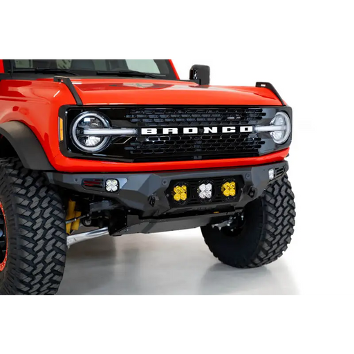 Red truck featuring Addictive Desert Designs 21-22 Ford Bronco Bomber Front Bumper with Baja Designs LP4 mounts.