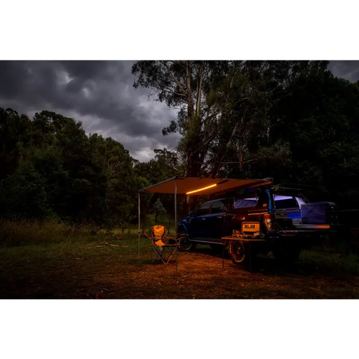 Arb awning kit with light installed, truck parked in woods at night