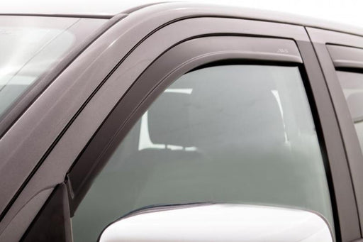 Dog sitting in passenger seat of car with avs low profile window deflectors - matte black