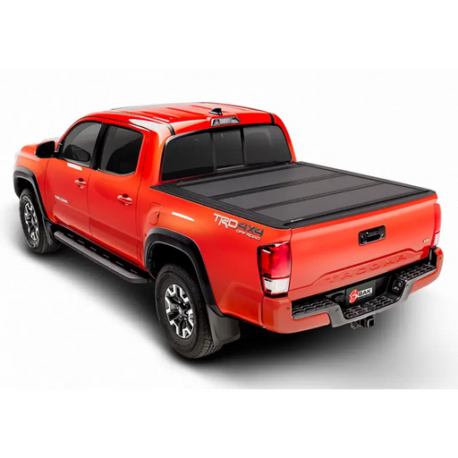 Red truck with black bed cover - BAKFlip MX4 Matte Finish for 05-15 Toyota Tacoma (6ft Bed)