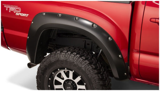 Red truck with black tire cover featuring bushwacker pocket style fender flares for toyota tacoma