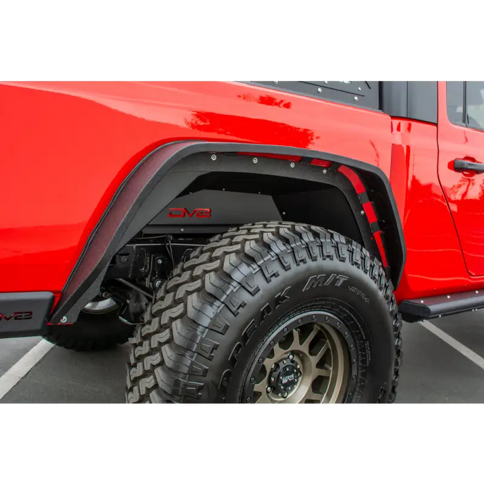 DV8 Offroad Red Jeep Gladiator with Big Tire in Parking Lot