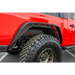 DV8 Offroad Red Jeep Gladiator with Big Tire in Parking Lot