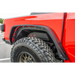 DV8 Offroad Jeep Gladiator Rear Inner Fenders - Black: Red truck with big tire in parking lot
