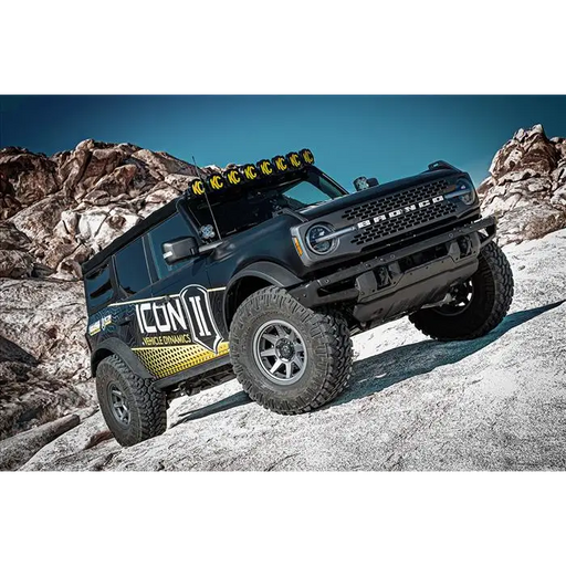 Black truck with yellow and black decal, ICON 21-UP Bronco lift system for larger tires and suspension travel.