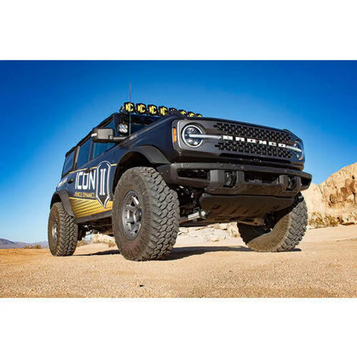 ICON Bronco Sasquatch Suspension System with Jeep Wrangler parked in desert.