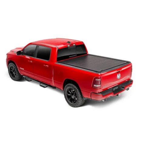 RetraxPRO XR truck bed cover on red Tacoma with black Trax Rail slot accessories.