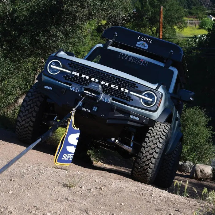 Jeep with blue and white flag on it displaying Superwinch Winch Rope Dampener.