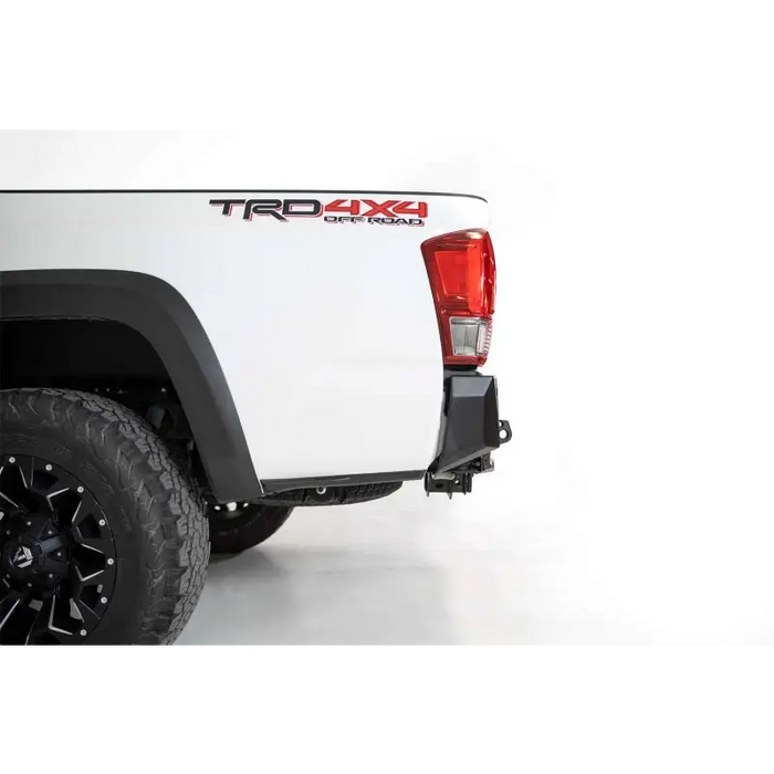 White truck with black rim and red tail light from Addictive Desert Designs Toyota Tacoma Stealth Fighter Rear Bumper.