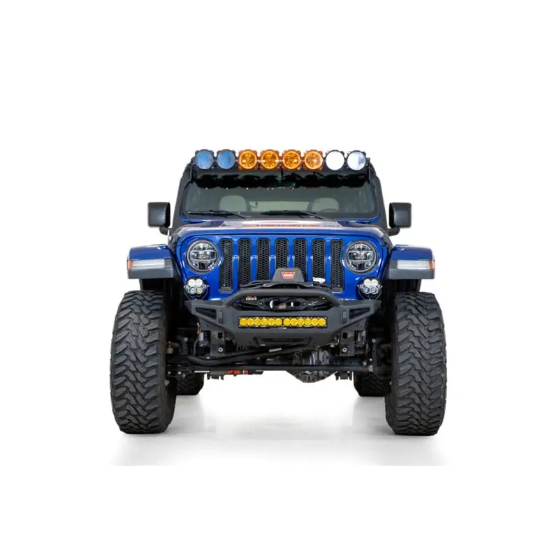 Close up view of blue jeep with lights on it from addictive desert designs rock fighter front bumper.
