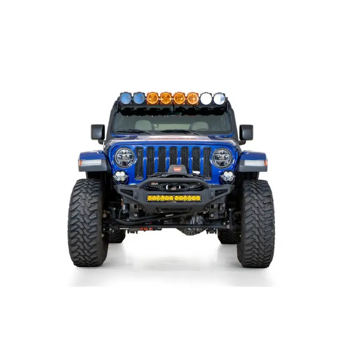 Close up view of blue jeep with lights on it from addictive desert designs rock fighter front bumper.