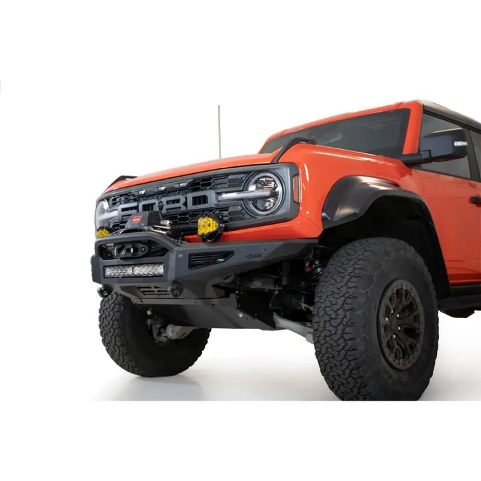 Red truck front end with Addictive Desert Designs 22-23 Ford Bronco Raptor Rock Fighter Skid Plate.