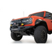 Red truck front end with Addictive Desert Designs 22-23 Ford Bronco Raptor Rock Fighter Skid Plate.