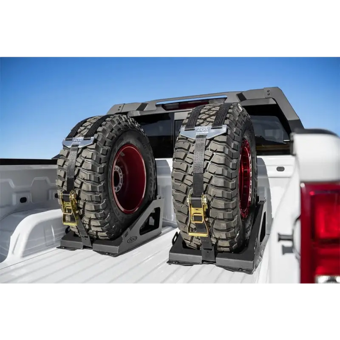 Rear view of white truck with two tires on Universal Tire Carrier.