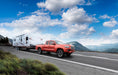 Red truck towing a trailer on road with air lift loadlifter 5000 air spring kit for toyota tacoma