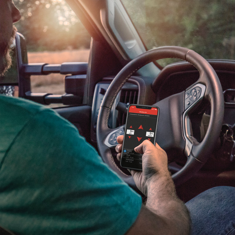 Man using smartphone while driving truck with air lift wireless air control system v2