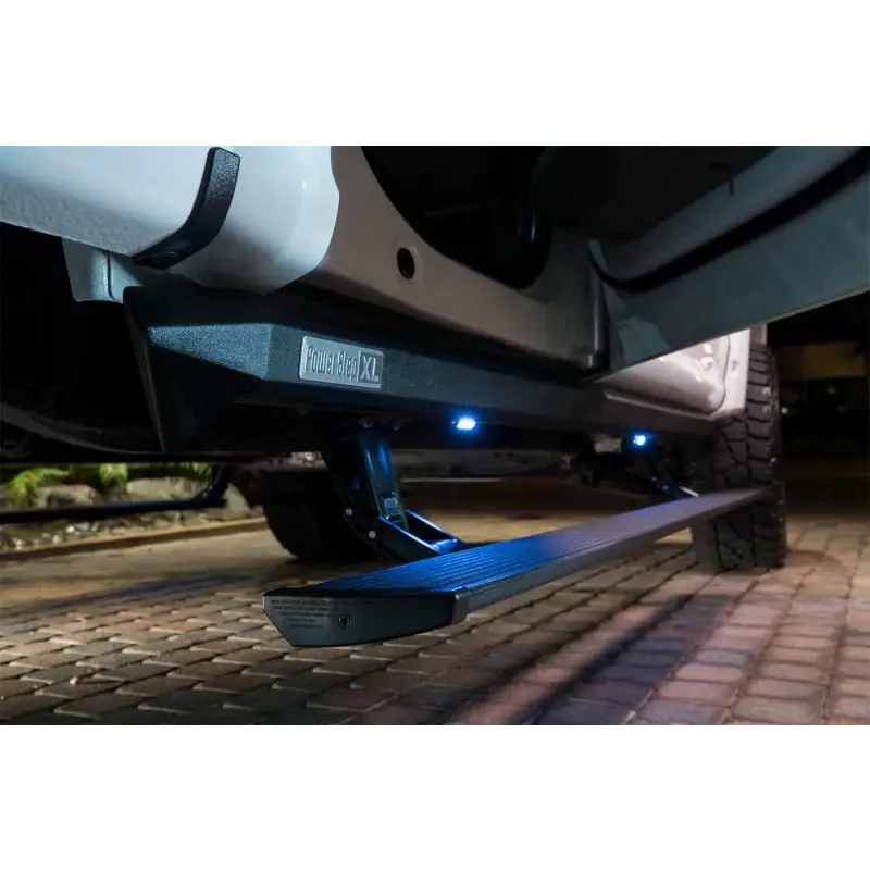 AMP Research 18-24 Jeep Wrangler JL 2DR PowerStep XL with OEM Style Illumination - Black, showing car with light on side.