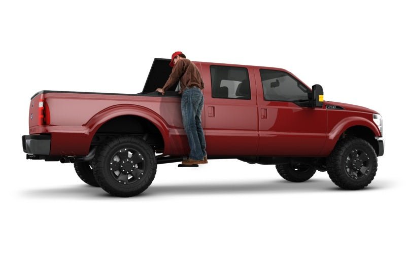 Man standing in back of red chevrolet silverado truck - amp research bedstep2 - black