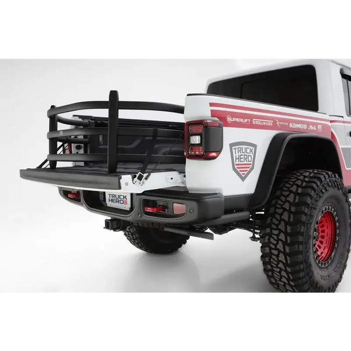 AMP Research Bedxtender HD Sport for Jeep Gladiator with red and white striped truck.