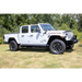 AMP Research Jeep Gladiator PowerStep XL in Black parked in a field with trees.