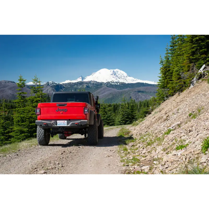 Red truck driving down dirt road beside ARB 20-21 Jeep Gladiator JT Rear Bumper.