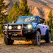 Blue truck parked in front of mountain with trees, showcasing arb 2021 ford bronco summit winch bumper