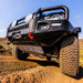 Black Jeep driving on dirt road showcasing ARB 2021 Ford Bronco Under Vehicle Protection - Transfer Case UVP