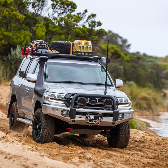 Arb base rack mount kit with deflector on truck driving down muddy road.