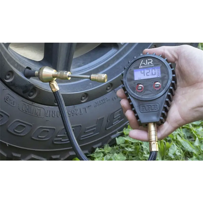 ARB E-Z Deflator Digital Gauge - Hand holding tire pressure gauge