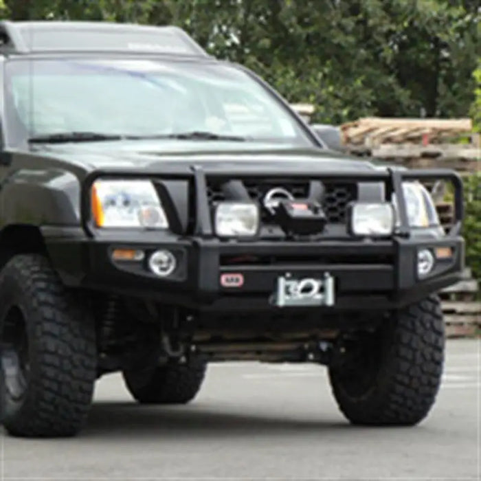 Black truck with big tire featuring ARB Fog Light Kit ARB Sahara 55W.