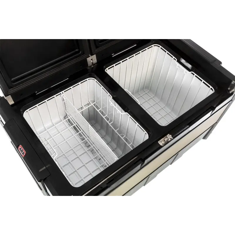 Black and white stove with two pans next to ARB Fridge 101 Quart DZ Zero B Plug