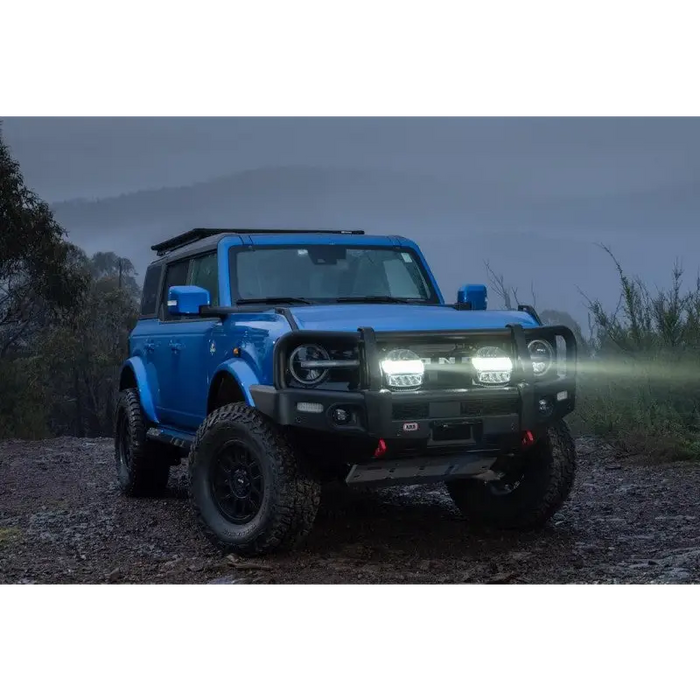 Blue truck with fog in front spotlighted by ARB Intensity IQ Driving Lights