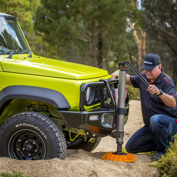 Man using power hammer to remove tire on ARB Jack Base - 15400lbs Load Capacity