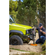 Man using power tool to remove tire with ARB Jack Base - 15400lbs Load Capacity.