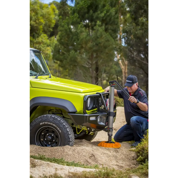 Man using power tool to remove tire with ARB Jack Base - 15400lbs Load Capacity.