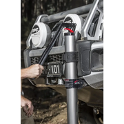 Hydraulic technology farm jack shown on a jeep with hand on handle