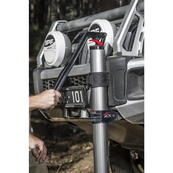 Hydraulic technology farm jack shown on a jeep with hand on handle