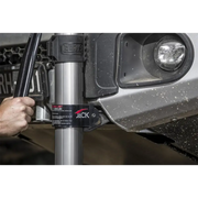 Man using ARB Jack to fix car’s front bumper with hydraulic technology.