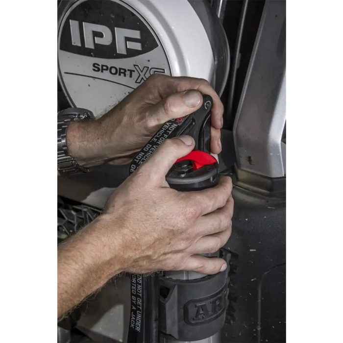 Man using hydraulic technology on ARB Jack to fix tire.