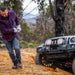 Man using ARB Premium Recovery Kit S2 snatch strap on trail with toy car