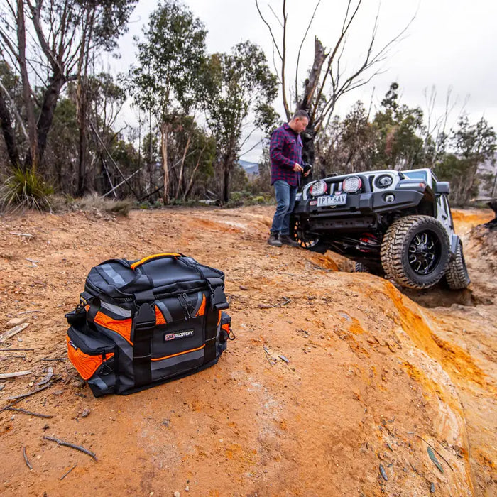 Man in purple shirt with black backpack on dirt road, ARB Premium Recovery Kit S2.