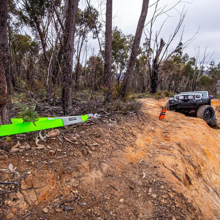 ARB Premium Recovery Kit S2 with car driving down dirt road and trees in background.