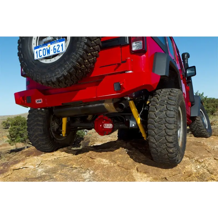 Red Jeep with Summit rear bumper parked on rocky hill