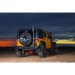 Rear view of yellow Jeep Wrangler with black tire cover