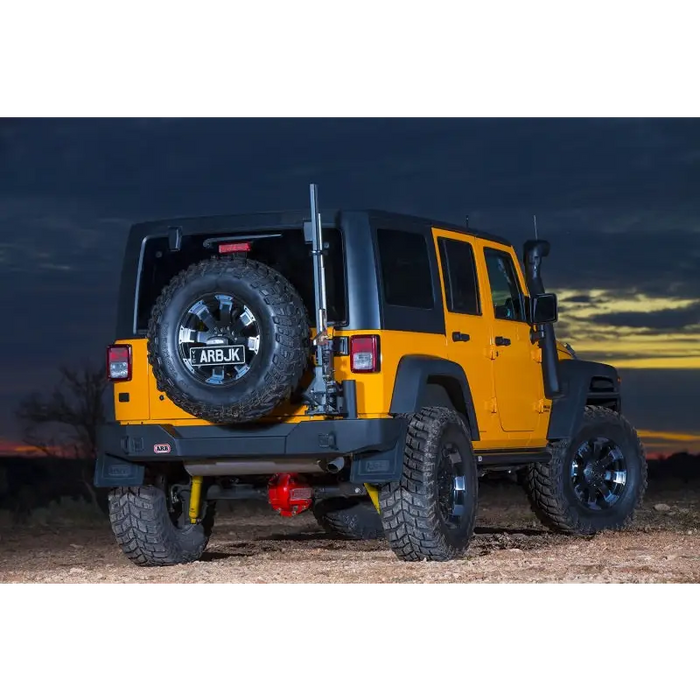 Jeep Wrangler parked in desert at night.