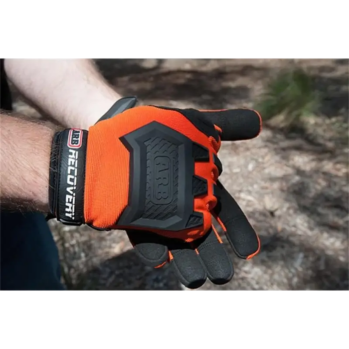 Man wearing orange ARB Recovery Glove with black and white lettering