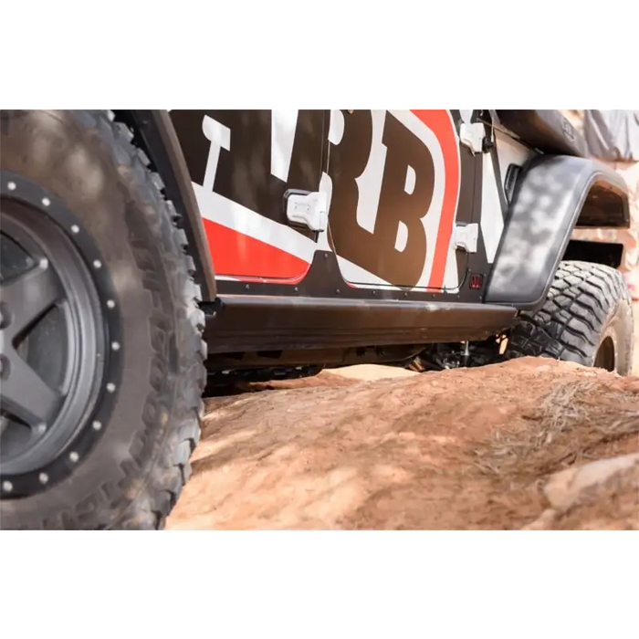 Man standing next to Jeep Wrangler on rock slider - ARB R/T/Rail Suits Jl 4 Door