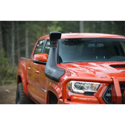Red truck driving down dirt road with ARB Safari 4x4 Snorkel displayed