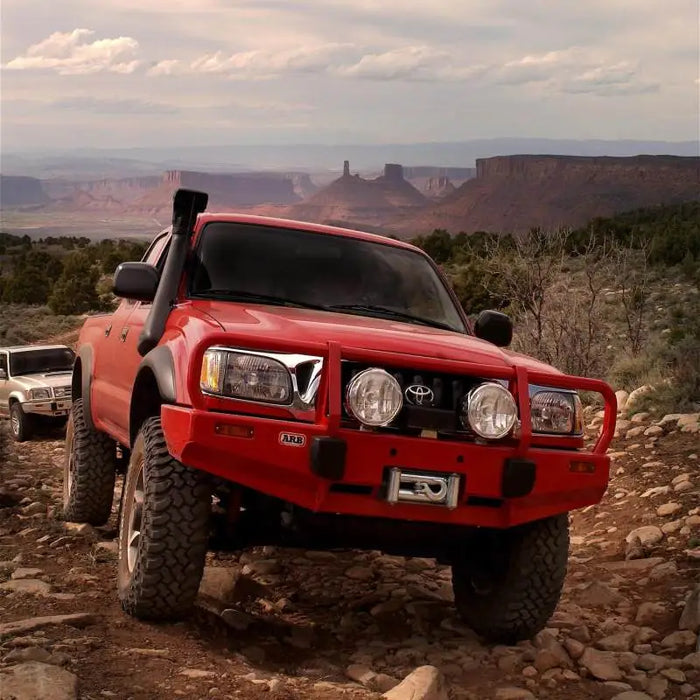 Red truck driving down rocky road - ARB Safari 4x4 Snorkel Vspec for Tacoma Gen 1 V6 3.4L Pet